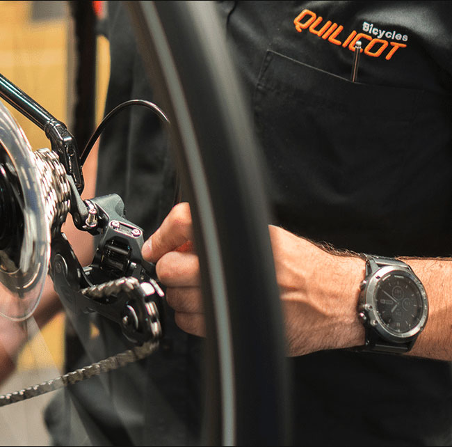 Man repairing a bicycle to illustrate our Magento project with the client Quilicot.